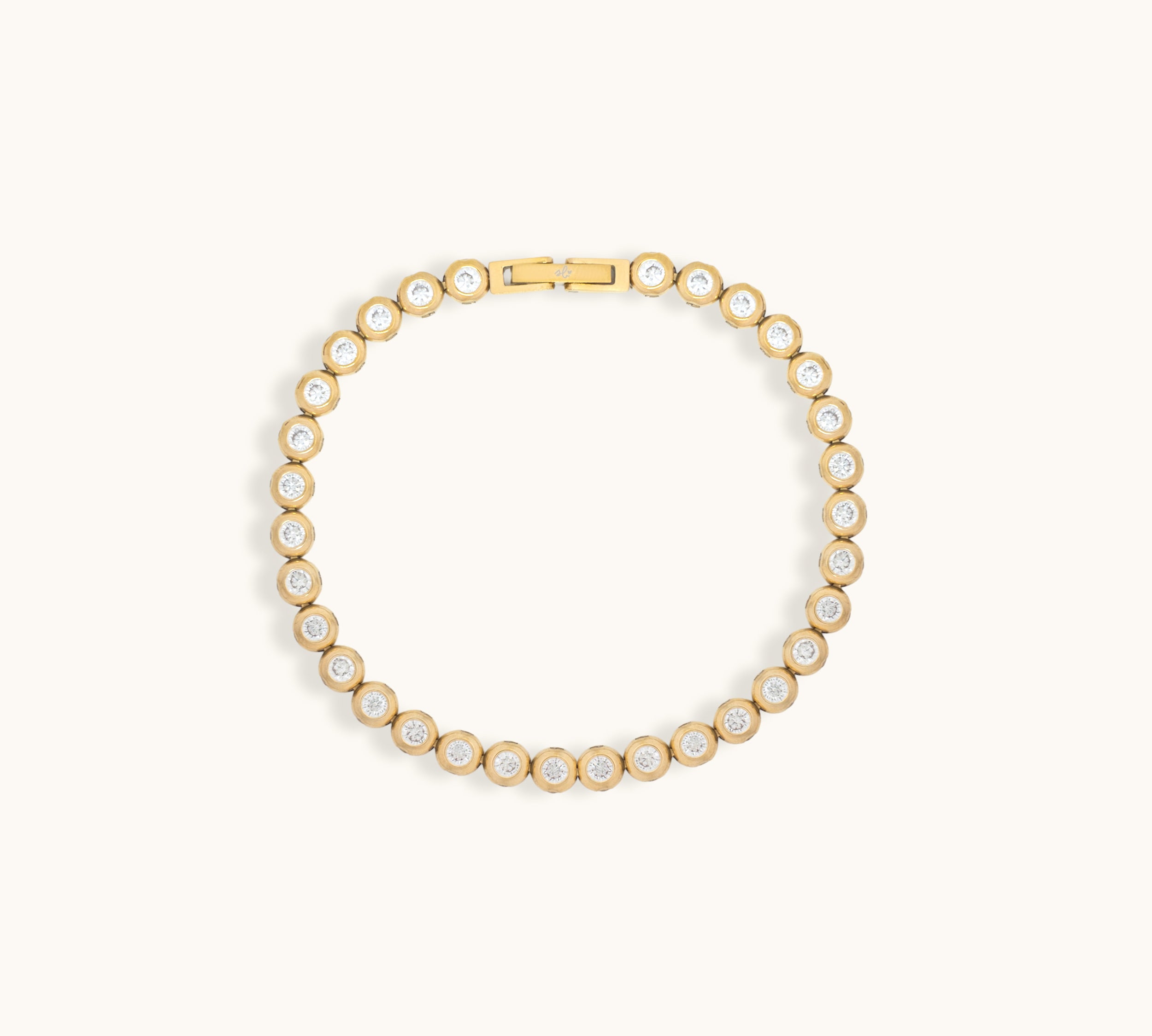 Gold tennis bracelet with cubic zirconia stones on a light beige background