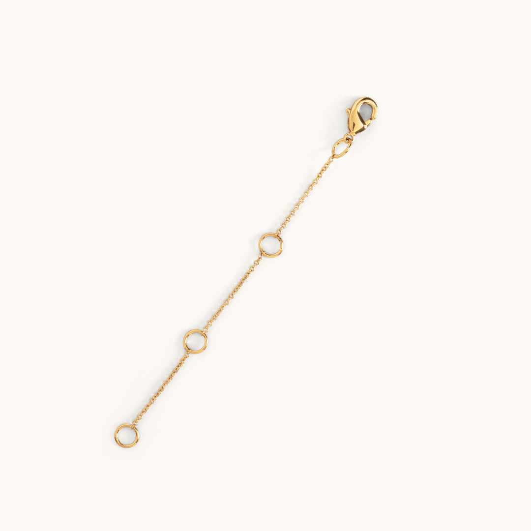 A gold-plated extender chain with multiple jump rings to adjust the length and a clasp at one end.